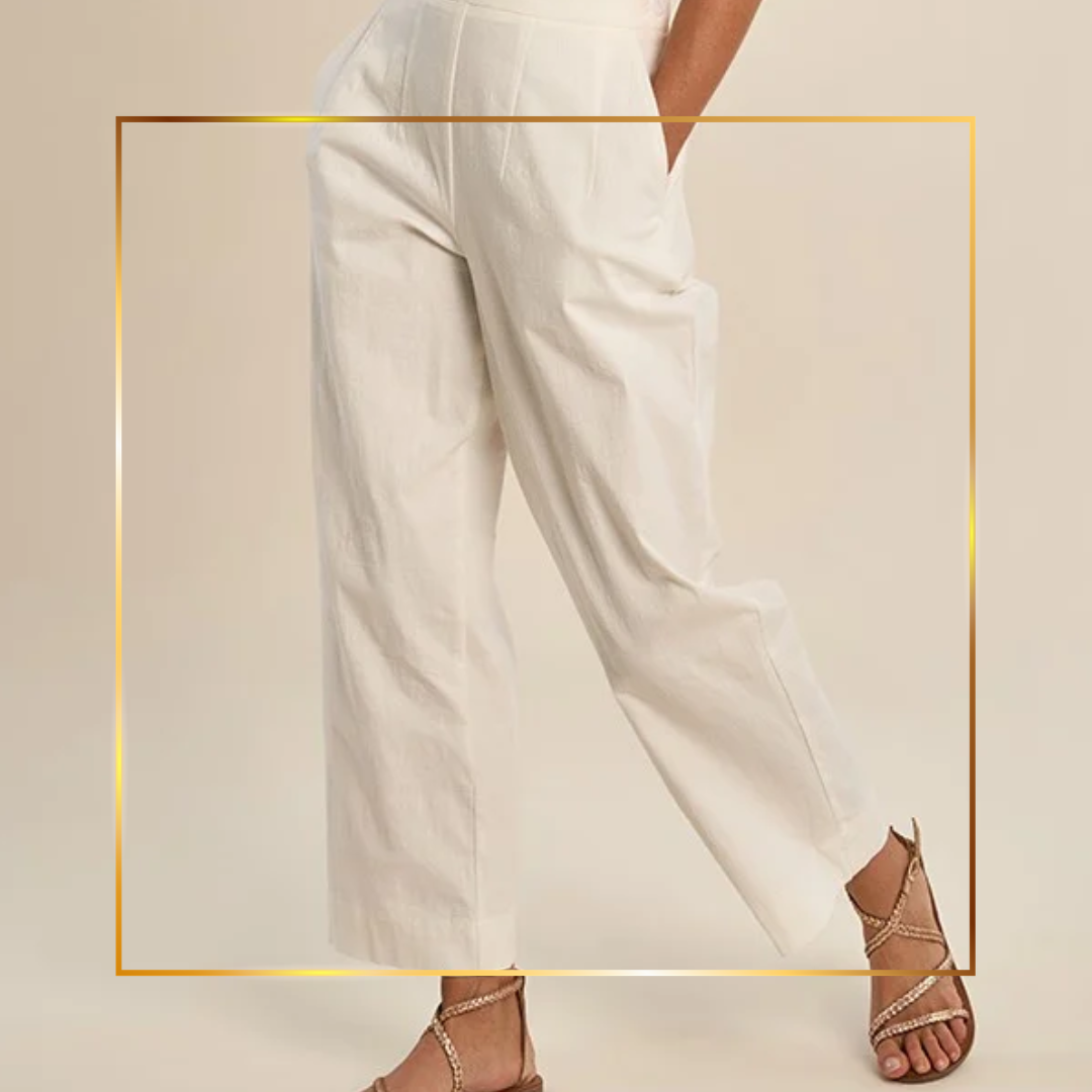 Model wearing silver jeans and pink closed toe heels on a plain background