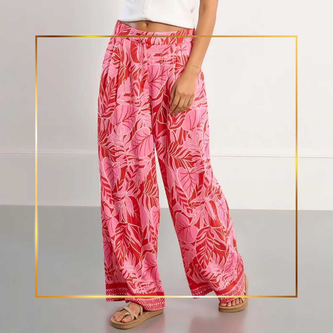 Model wearing silver jeans and pink closed toe heels on a plain background