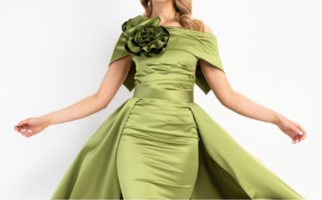 Woman wearing a green dress with a floral detail on a white background